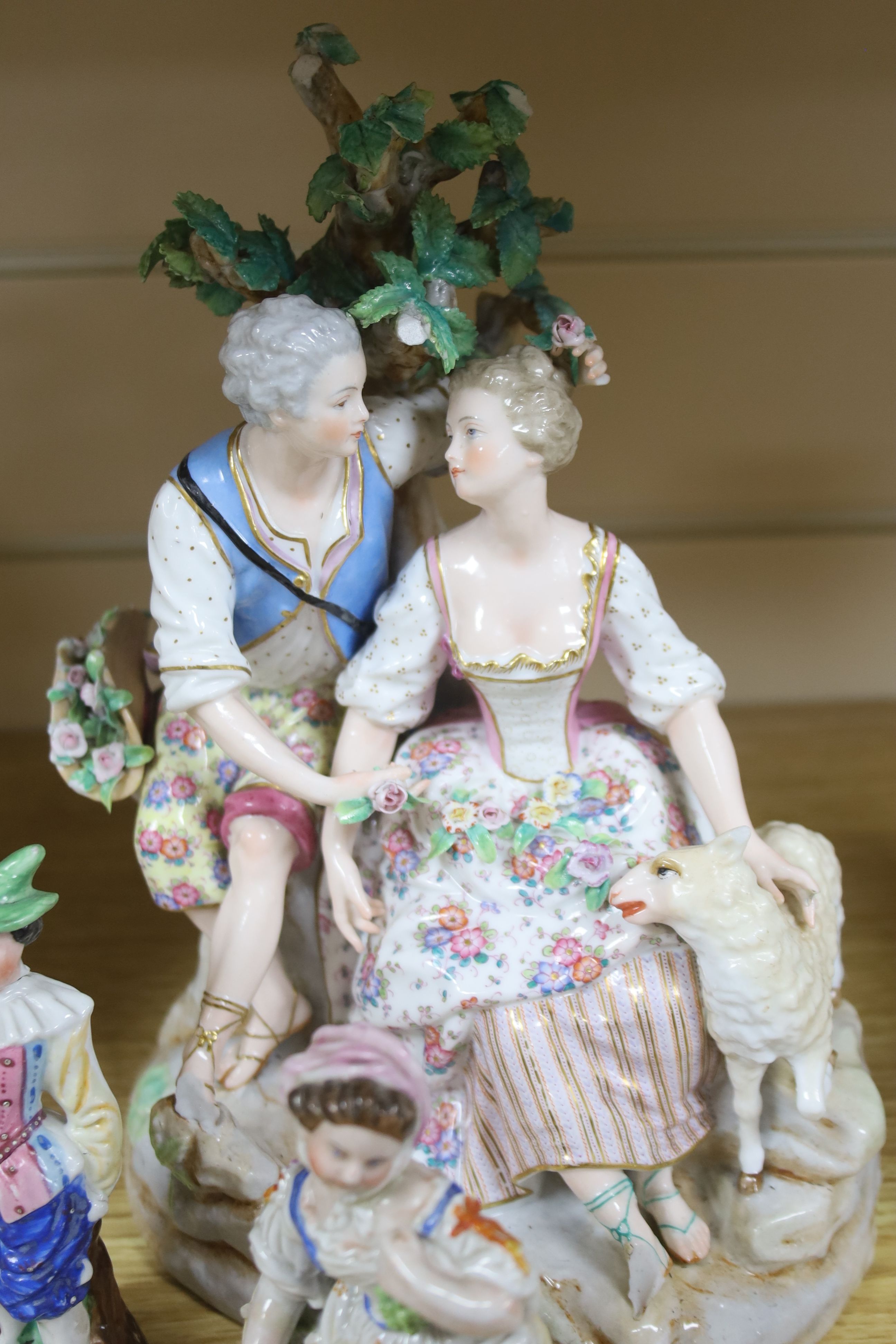 A pair of Meissen style porcelain groups and three other figures, tallest 26cm